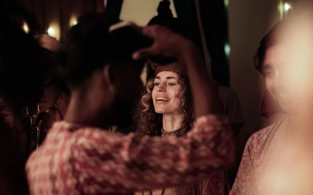 Friends laughing together during an evening of kirtan