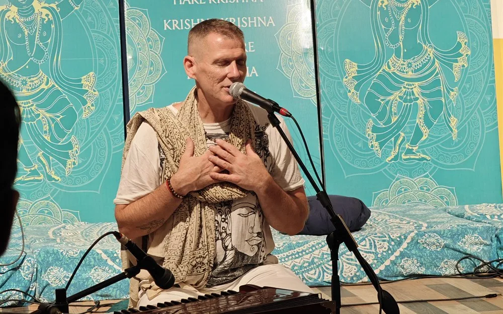 Recording a talk in front of the kirtan hall backdrop