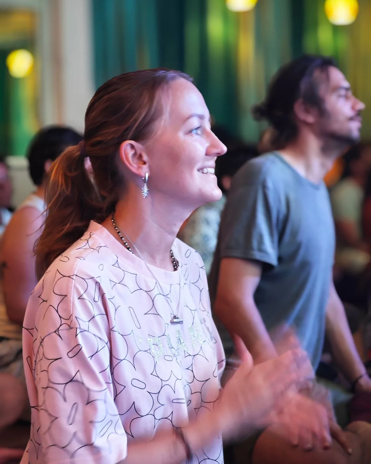 A friend laughing and clapping in the middle of the kirtan