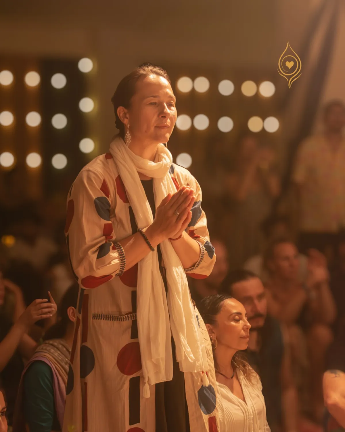A participant stands with folded hands during an evening gathering