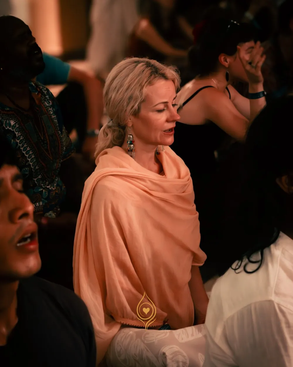A first-time visitor singing softly with closed eyes at a Bhakti Yoga Rishikesh kirtan