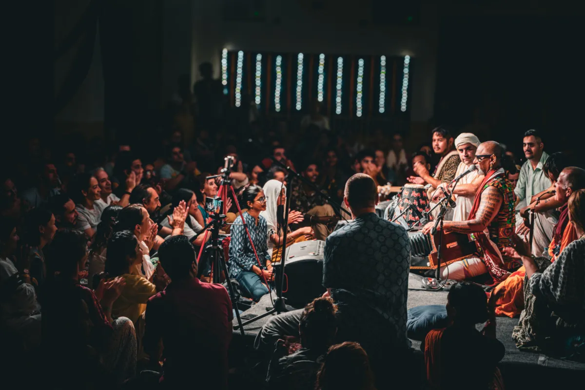 Musicians at the centre of a packed hall during Kirtan Mela in Rishikesh